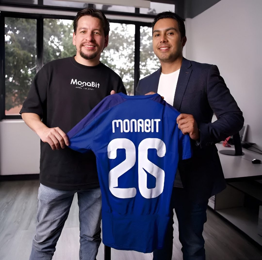 Diego Osuna, CEO de MonaBit, y Carlos Valenzuela, de Win Sports, con una camiseta MonaBit 20.